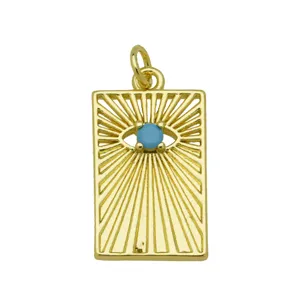 Vista detallada de un colgante rectangular dorado con diseño de sol y ojo azul