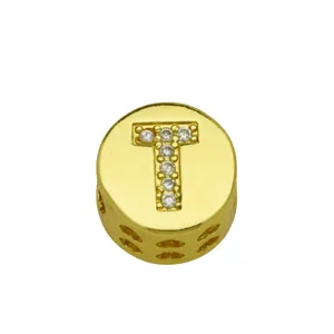 Close-up of gold circular letter T charm with sparkling stones and heart cutouts