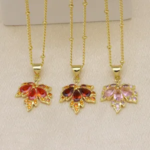 Closeup of three exquisite maple leaf pendant necklaces featuring colorful zirconia stones detail.