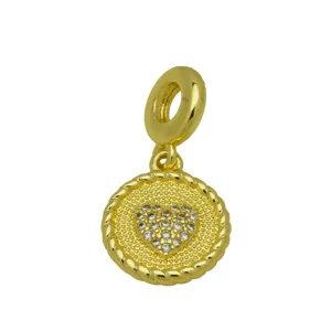 Detailed view of a golden charm pendant with braided edge and sparkling crystal paved heart.