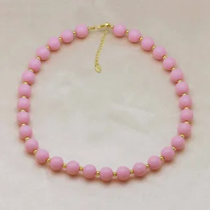 Gros plan détail du collier de perles roses fait main avec des perles d'espacement.
