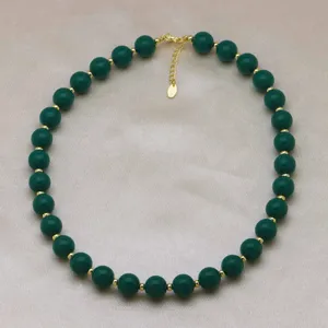 Elegantes collier de perles vertes avec des perles dorees comme accessoire de mode pour dames.