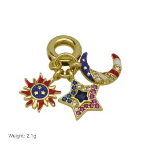Detailed shot of gold-plated sun star and moon charm with colorful enamel and sparkling crystals.