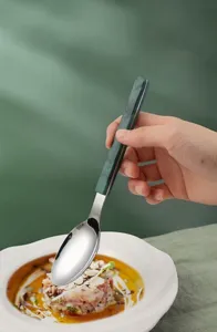 Detailed view of the stainless steel dining spoon with green marble pattern handle, elegant texture.