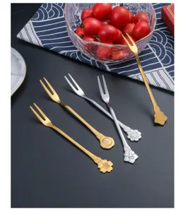 Dettaglio di forchette da frutta in acciaio inossidabile con eleganti manici decorati a fiore.