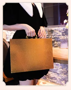 Gold embossed cutlery storage case detailed view, elegant textured metal box with handle.