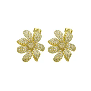 Close-up of gold-plated flower stud earrings encrusted with sparkling cubic zirconia stones.
