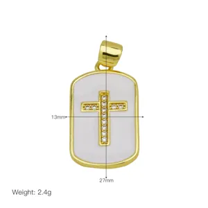 Detailed view of the 18K gold plated cross pendant featuring white enamel and sparkling zirconia.