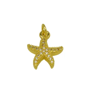 Primer plano detallado de un colgante de estrella de mar chapado en oro 18K con circonitas brillantes.