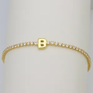 Detailed view of gold tennis bracelet featuring letter B charm and shimmering cubic zirconia.