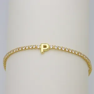 Close-up detail of the gold tennis bracelet featuring a sparkling letter P zircon charm.