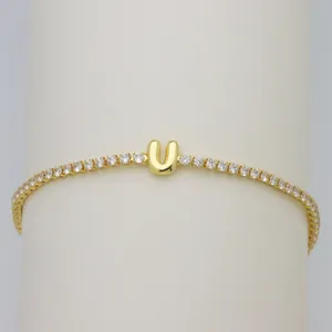 Gold tennis bracelet featuring a cute bubble letter U pendant sparkling with cubic zirconia stones.