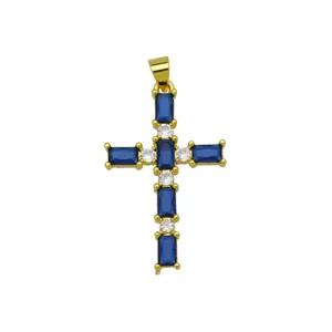 Close-up detail of a gold-plated cross pendant set with blue and white cubic zirconia stones.