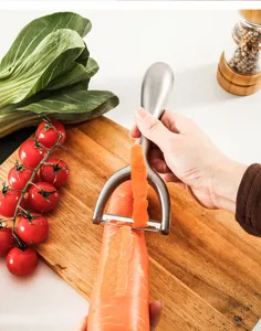 Stainless steel vegetable fruit peeler detail shot, showing efficient kitchen tool usage.
