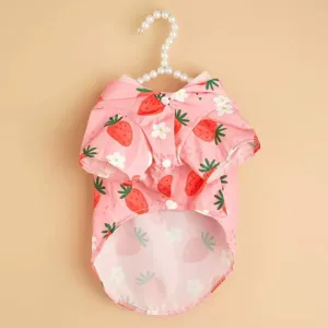 Vue détaillée du joli imperméable pour animaux rose avec motif de fraises et cintre.