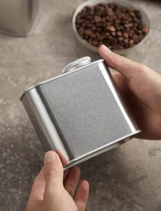 Stainless steel coffee canister detail view showing square brushed metal finish and threaded lid.