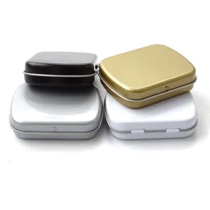 Vue détaillée de petites boîtes en métal carrées de couleurs noir, argent, or et blanc.