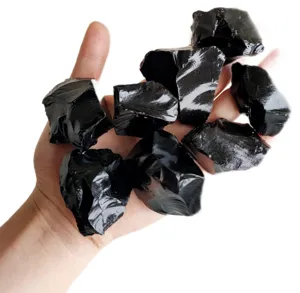 Raw black obsidian crystal raw stones detail shot, ideal for aromatherapy and decor.