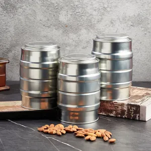 Detailed shot of silver barrel-shaped tin cans with screw lids, ideal for coffee and tea storage.