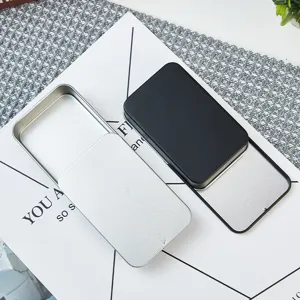 Vue détaillée de boîtes métalliques coulissantes vides en noir et argent pour objets.
