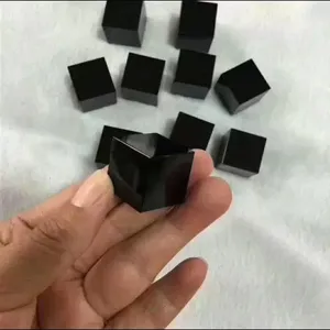Detail view of black obsidian crystal cube raw stone polished ornament, smooth and classic.