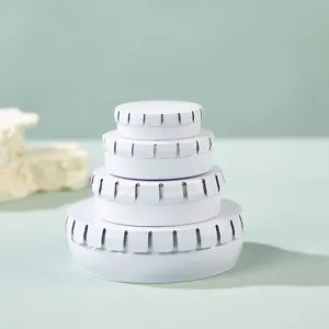 Detailed view of stackable white round metal press tin boxes for cosmetics, mints, and pills.