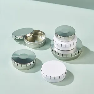 Round metal tin boxes for cosmetics, lip balm, candy, and small pills. Detail view.