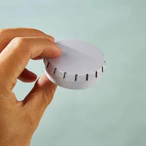 Portable round white metal tin box for lip balm, cosmetics, candy, or pills. Compact design.