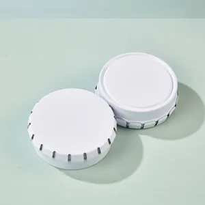 Detail view of white round metal tin boxes, press-top storage container for pills, lip balm.