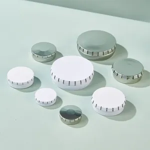 Detail view of small round metal tins, white and silver storage boxes for pills, balm.