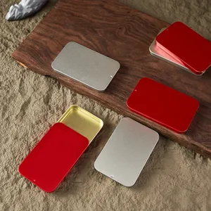 Detail view of portable sliding tin boxes for jewelry, pills, and candy storage in red and silver.