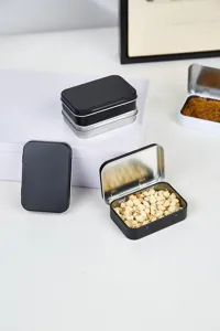 Gros plan de boîtes métalliques rectangulaires à charnière, en noir et argent, pour le rangement.