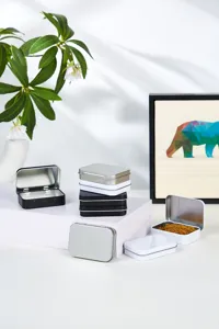 Vue détaillée de petites boîtes en métal noir, blanc et argent pour le rangement d'objets.