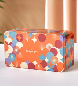 Gros plan d'une boîte à biscuits en métal rectangulaire avec un motif géométrique coloré.