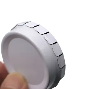 Round metal tin box detail showing white coated surface and rim structure for small storage.
