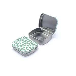 Petite boîte en métal carrée avec motif de feuilles vertes et couvercle rabattable pratique.
