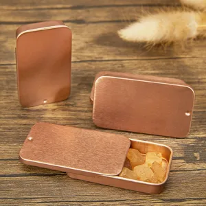 Vue détaillée de boîtes métalliques coulissantes en or rose pour le rangement de bijoux.