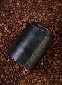 Vista dettagliata di un barattolo in metallo nero vintage, ideale per conservare i chicchi di caffè.