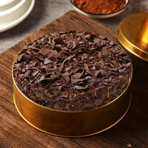 Boîte en métal dorée ronde avec gâteau au chocolat, emballage cadeau et contenant de stockage.