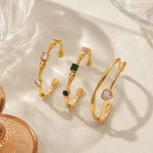 Close-up of three 18K gold-plated hammered bracelets with heart and colorful zircons