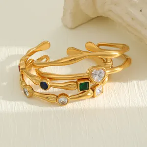 Close-up of 18K gold plated titanium steel bangles with colorful zircon heart details.