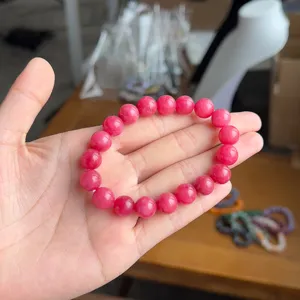 Close-up detail of the pink stone bead bracelet, showcasing smooth round beads and texture.