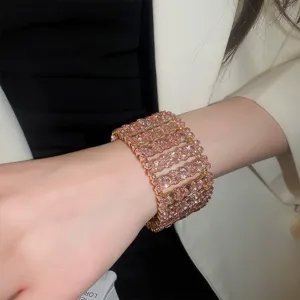 Nahaufnahme Detail des breiten rosa Kristall Strass Armbands mit eleganter goldener Fassung.