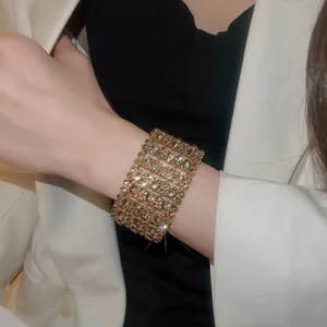 Detaillierte Nahaufnahme des breiten, mehrreihigen glitzernden Strass-Armbands am Handgelenk.