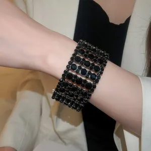 Nahaufnahme Detailaufnahme des breiten, mehrreihigen schwarzen Strass-Armbands am Handgelenk.