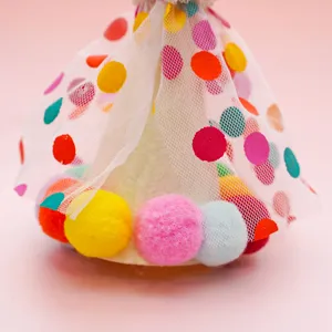 Pet birthday hat detail view, colorful polka dots mesh tulle and cute fluffy pom-poms.