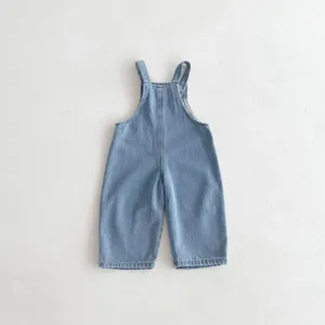 Close up detail of baby denim overalls, light blue wash cotton fabric, casual cute style.