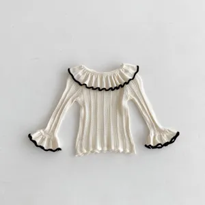 Mädchen Strick Oberteil Detail mit süßem Rüschenkragen und schwarz besetzten Ärmeln.