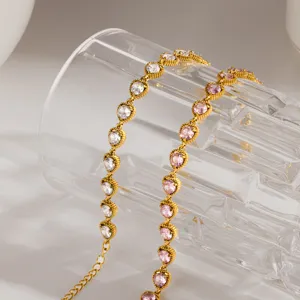 Vista detallada de pulsera de acero inoxidable dorada con circonitas blancas y rosas brillantes.