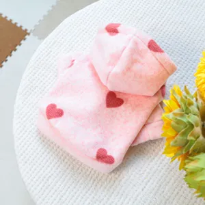 Detalle en primer plano de linda sudadera con capucha rosa para mascotas con corazones, suave.